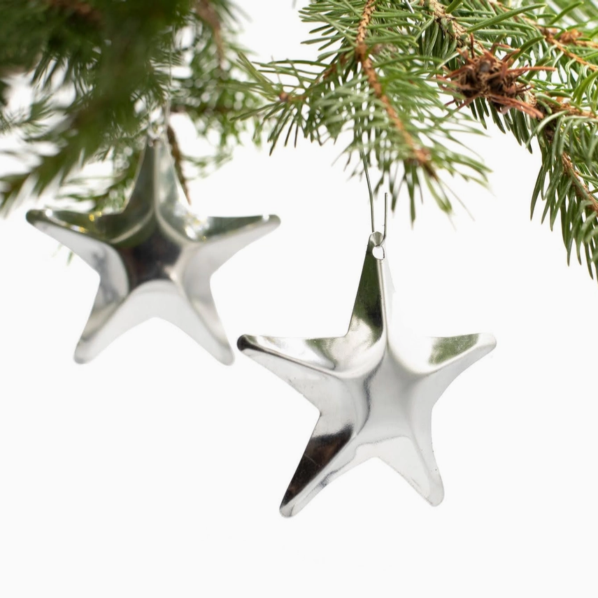 Silver star-shaped Christmas ornaments hanging on a green pine branch. Tin Christmas Tree Stars Pietersma Tinworks product_type art-noise.myshopify.com tin-christmas-tree-stars