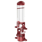 A bird feeder with a clear cylindrical body, dark red top cap, and dark red base and perching cups, shown on a plain white background.