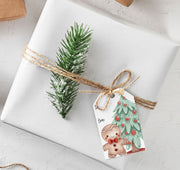 Gift wrapped in white paper with a decorative tag featuring a gingerbread man and Christmas tree design. Gingerbread Gift Tags Creativien product_type art-noise.myshopify.com gingerbread-gift-tags