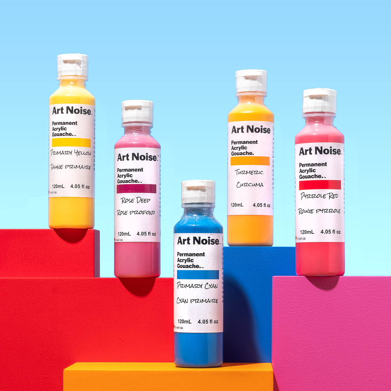 Five bottles of Art Noise acrylic gouache on a colorful geometric background